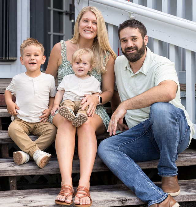 Trevor and his family sitting together on porch steps